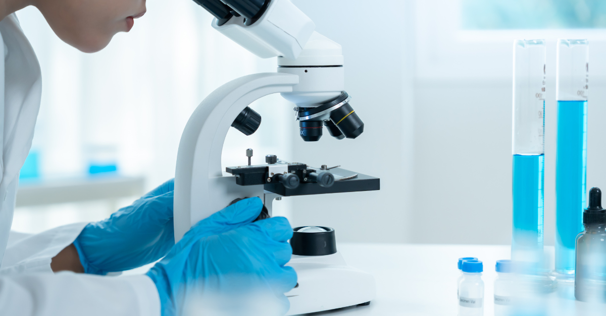 A scientist in a laboratory looking into a microscope