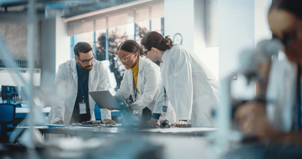 A group of scientists observing results on a laptop