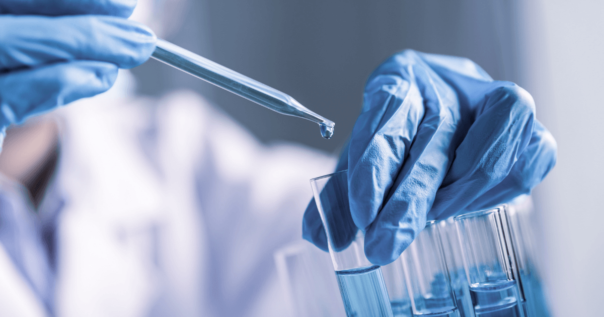 A scientist dropping liquid into a test tube